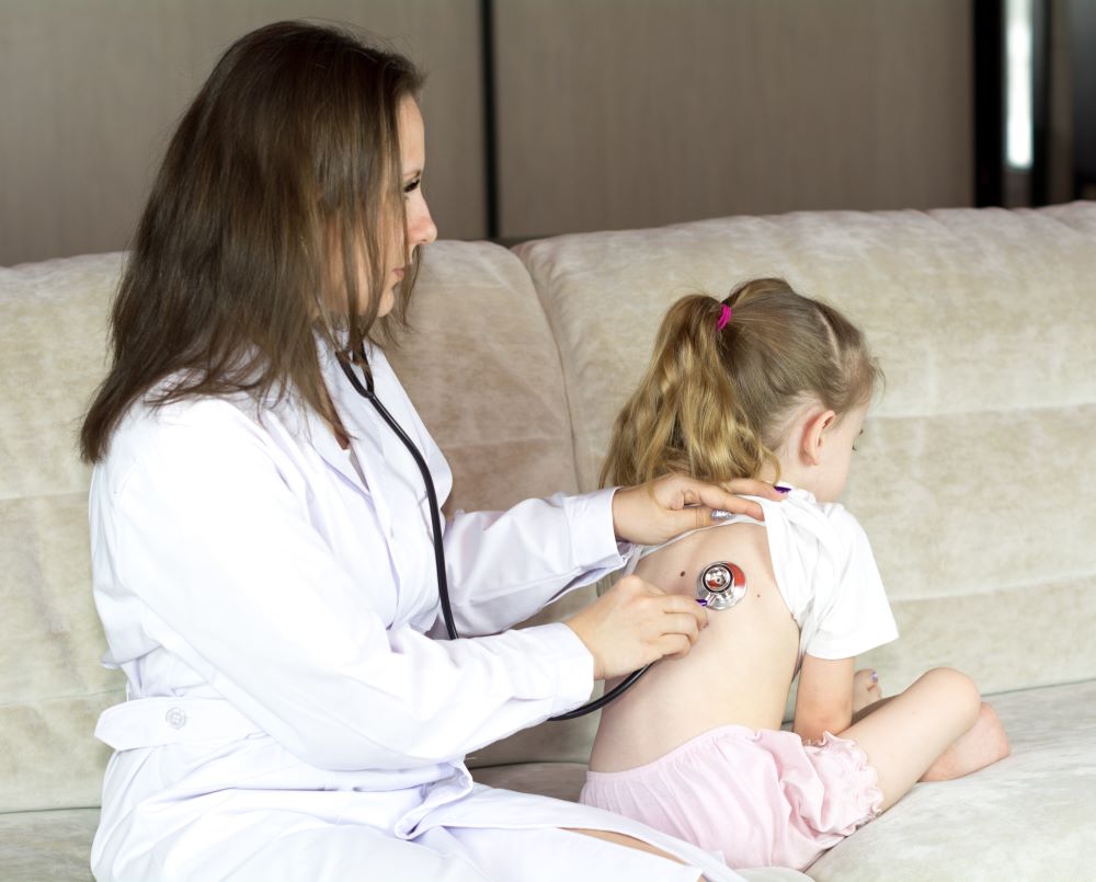 doctor examining breathing on little girl 